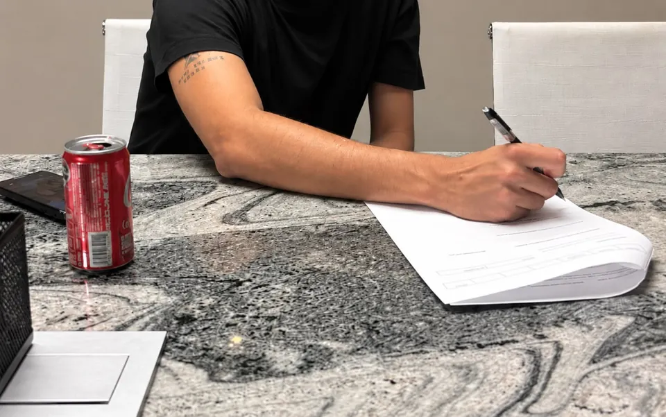 Primer plano de una firma de documentos en una operación de Domova.